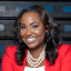 Black woman in a red blazer smiling